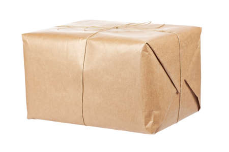A parcel wrapped in brown paper and tied with rough twine, isolated on white background. Shallow depth of fieldの写真素材