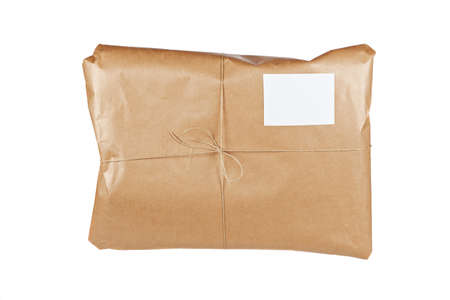 A parcel wrapped in brown paper and tied with rough twine, isolated on white background. Shallow depth of fieldの写真素材