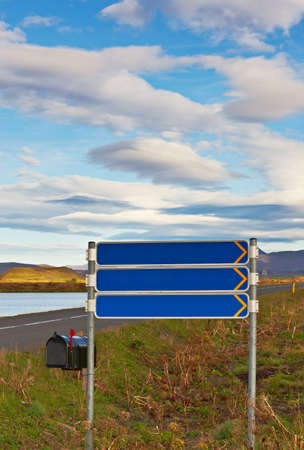 Mailbox and tourist signpost under cloudy skyの写真素材