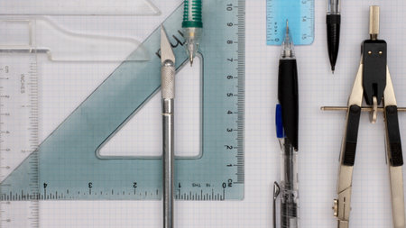 Drafting architectural tools arranged on white quartile paper flay lay