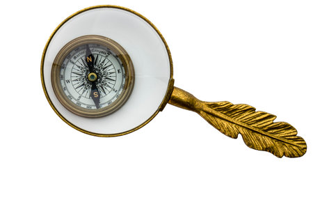Vintage look compass under magnifying glass, isolated on white background, concept of examining direction in lifeの写真素材
