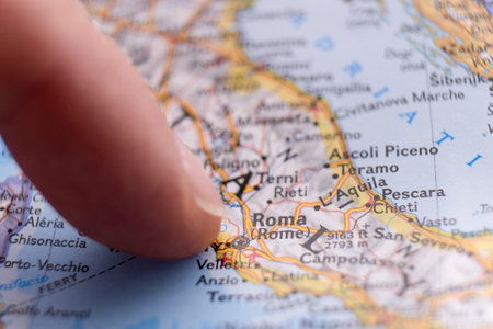 Finger pointing to Rome, Italy on detailed map with selective focus, shallow depth of field,...