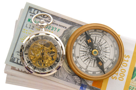 Stack of 10.000 in hundred dollar bills with a compass, modern pocket watch placed on top, white backgroundの写真素材
