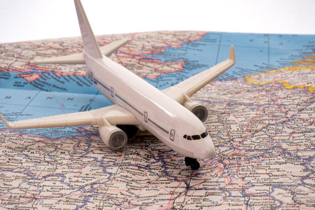 Close up of a miniature passenger plane on a colorful map, globe, showing Europe, Paris through selective focus, background blurの写真素材