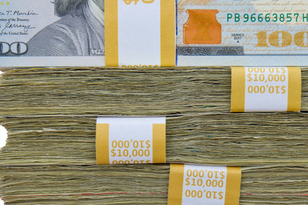 Close up side view of 4 straps of ten thousand, one hundred US dollar bills stacked on top of each otherの写真素材