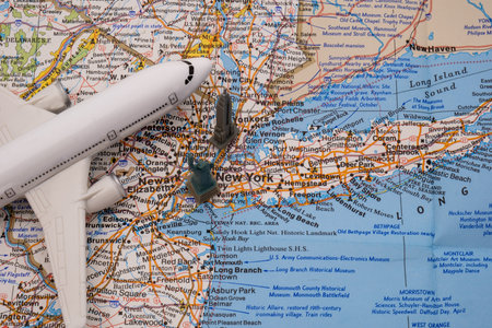 Close up detail of a miniature passenger plane on a colorful map of New York with a toy Empire State building, Statue of Libertyの写真素材