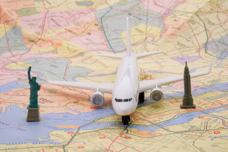 Close up detail of a miniature passenger plane on a colorful map of New York with a toy Empire State building, Statue of Libertyの写真素材