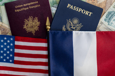 Flags staff of United States and France on passports and currency flat lay