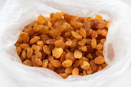 Fresh raisins in a plastic bag on a white background.の写真素材