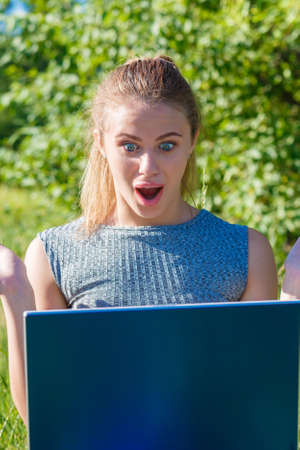 Girl shows how very surprised and happy about that of a computer monitorの写真素材