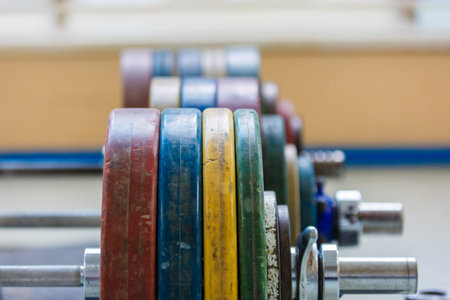 Multi-colored discs for the rod. Rod with with colored discs. A lot of weight in the gym