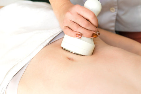Body massage with cavitation. Young girl on massage table