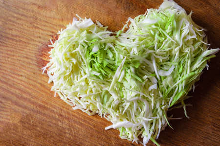 White cabbage and carrots finely chopped in the shape of a heart. Concept of love for vegetarian cuisine and raw vegetables.の写真素材