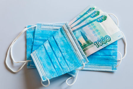 Medical masks and banknotes of Russian currency as a symbol of higher prices for respiratory...
