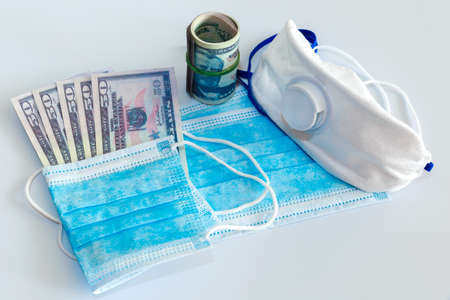 Medical masks and 50 dollars bills as a symbol of increased prices for protecting the respiratory tract from viruses. There is a place for copyspaceの写真素材
