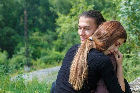 A man of Asian appearance embraces a young woman of European appearance. International love of...