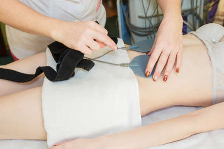 Body massage with cavitation. Young girl on massage tableの写真素材