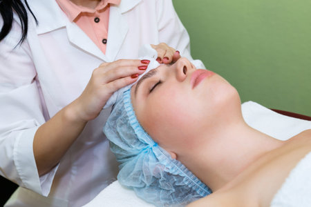 Close-up young woman in spa salon on facial skin care procedures. Facial skin rejuvenation and...