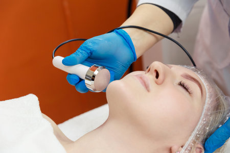 A young woman receives the procedure from a cosmetologist. Hardware korretsky face shape. Cavitation...