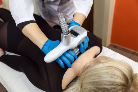 Process of LPG massage in the spa for a young woman in a dark transparent suit.