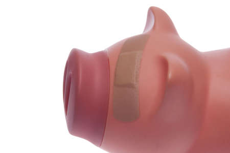Piggy bank with a plaster over its eye. の写真素材
