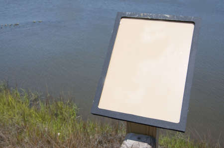 An educational display in a natural setting with grass, and ocean.  Depth of field shot with focus on the empty sign.  You can create artwork for the sign specific to your project or simply leave it blank.  Photograph was taken in North Carolina.の写真素材