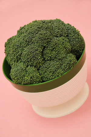 Vintage dish of broccoli on a pink background.  A colorful food studio shot.