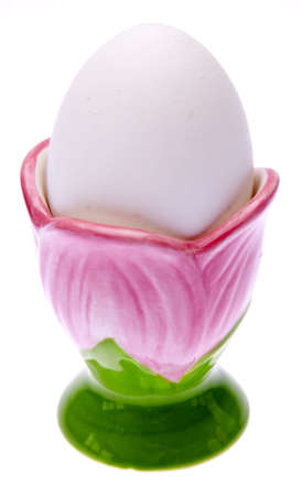 White Easter Egg in a Pink Flower Shaped Cup Isolated on White with a Clipping Path.の写真素材