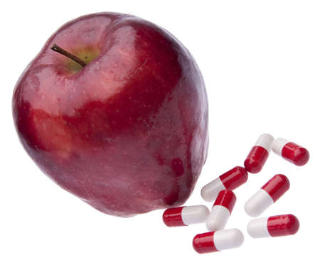 Apple with pills for diet, and healthcare themes.  Isolated on white の写真素材