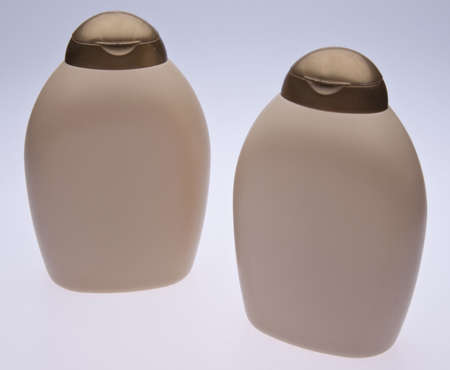 Shampoo and conditioner bottles with blank labels on a gradient background.の写真素材