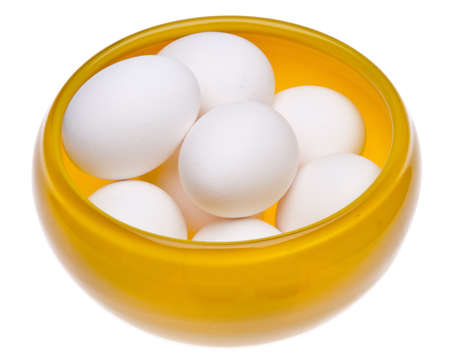 Yellow bowl full of fresh eggs.  Isolated on white with a clipping path.の写真素材