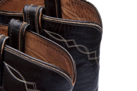 The tops of a pair of worn cowboy boots make a vintage looking western border.  Isolated on white.の写真素材