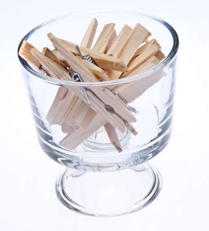 Time to do the laundry!  A glass full of clothespins isolated on white.の写真素材