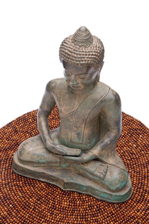 Meditating Buddha statue on a beaded mat の写真素材