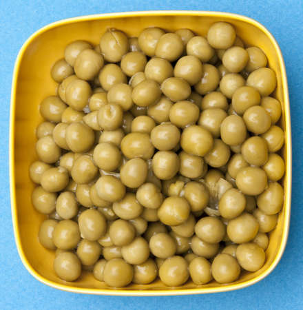 Bowl of canned peas on a vibrant blue background.の写真素材