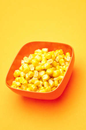 Vibrant bowl of canned corn on a yellow background.の写真素材