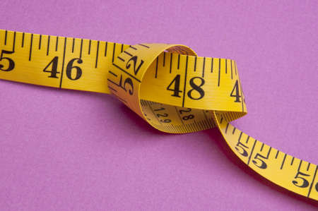 Knotted Measuring Tape on a Vibrant Background.の写真素材