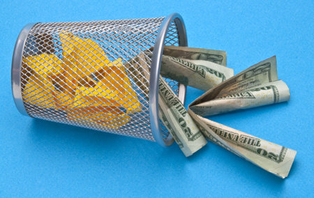 Trash Can with American Money Thrown Away on Blue Background.