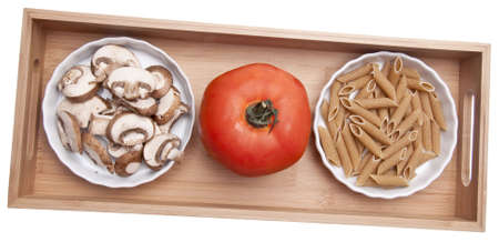 Pasta Making Ingredients Including Mushroom Slices, a Ripe Tomato and Dry Whole Wheat Pasta.の写真素材
