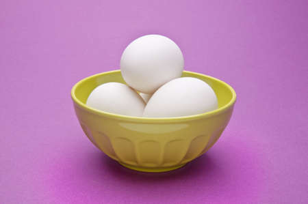 Eggs in a Green Bowl on Vibrant Purple.の写真素材
