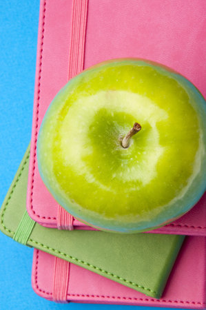 Health Care or Education Themed Image with Books and Apples on a Bright Blue Background.の写真素材