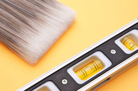 Home Improvement Scene.  Paintbrush and Level on Yellow.の写真素材