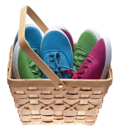 A basket of child sized shoes, concept for giving clothing to the needy.  Isolated on White の写真素材
