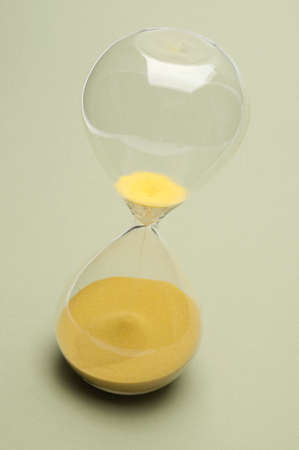 Hourglass with the sand almost all the way on the bottom to symbolize time running out.の写真素材