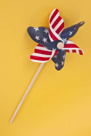 Pinwheel with USA Flag Pattern on a Vibrant Yellow Background.の写真素材