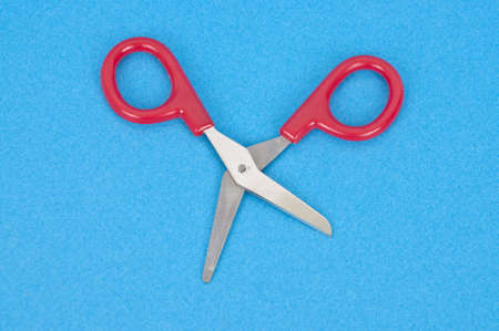 Quirky Red Scissors in a Dancing Pose on a Bright Blue Background.の写真素材