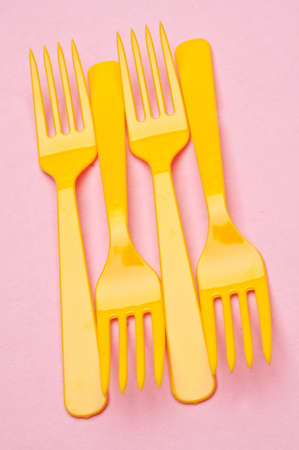 Fun Food Scene with Yellow Forks on a Pink Background.の写真素材
