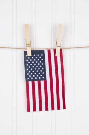 American Flag on a Clothesline Hanging Against a White Background.の写真素材