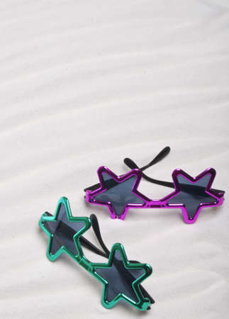 Fun Star Shaped Summer Sunglasses in the Sand.の写真素材
