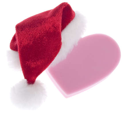 Give the Gift of Love this Holiday Season.  Concept Image with a Heart and Santa Hat Isolated on Whiteの写真素材